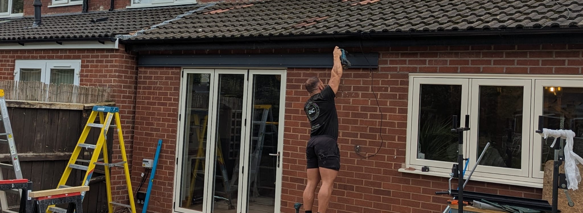An installer carefully fitting a fascia detail on a finished veranda
