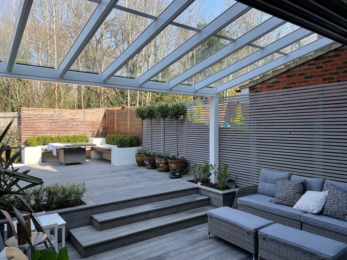 Veranda over decking with garden steps and woodland behind