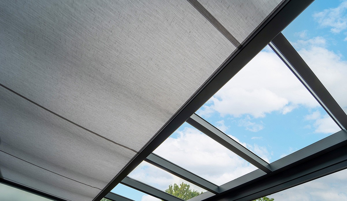 Motorised pleated roof blind on a glass-roofed veranda