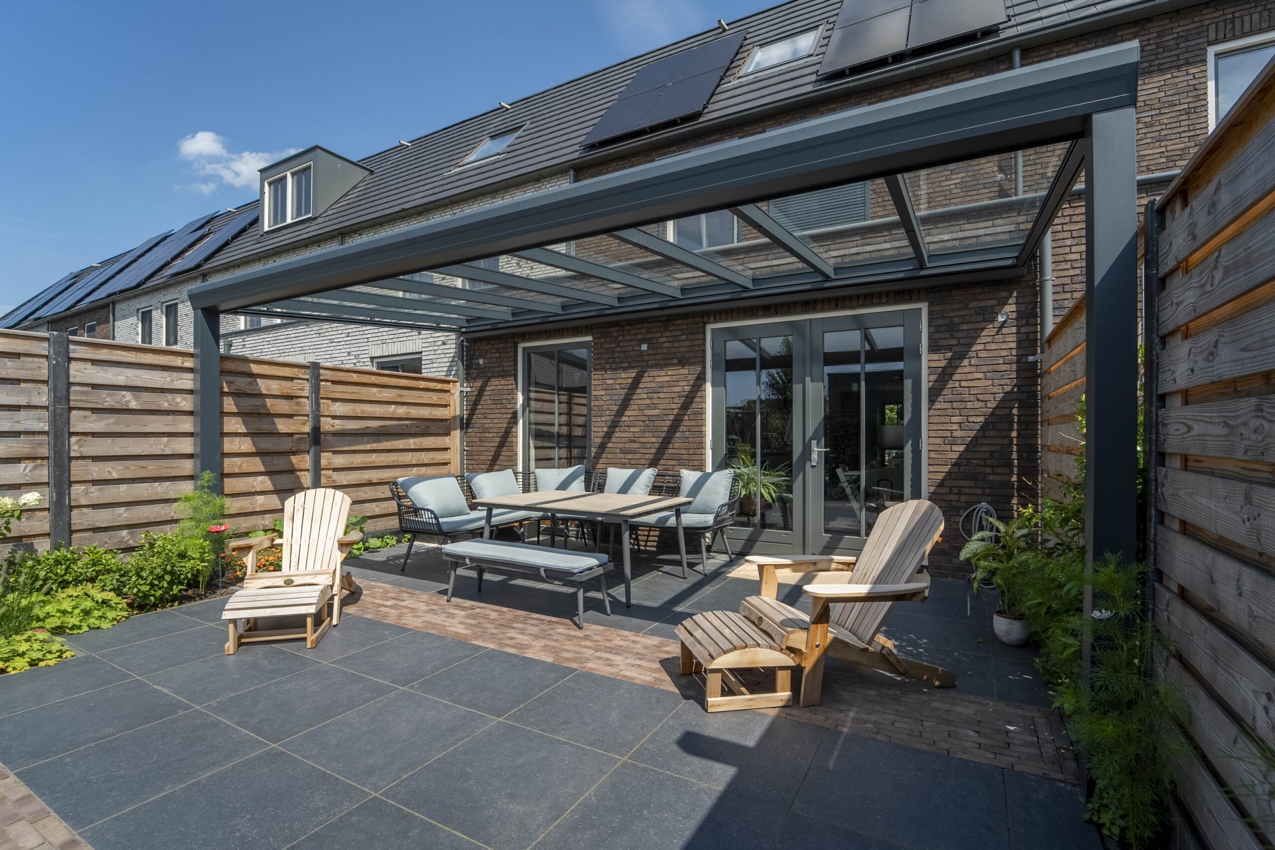 A long covered canopy in matt anthracite extending across a paved area