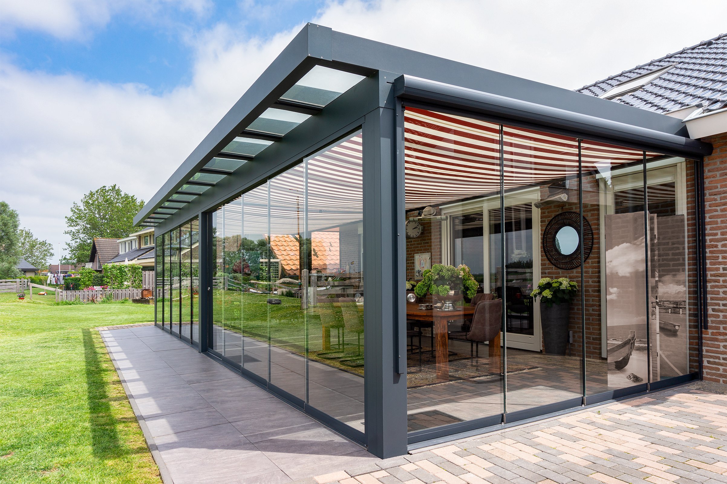 A finished premium glass garden room beside a red brick home