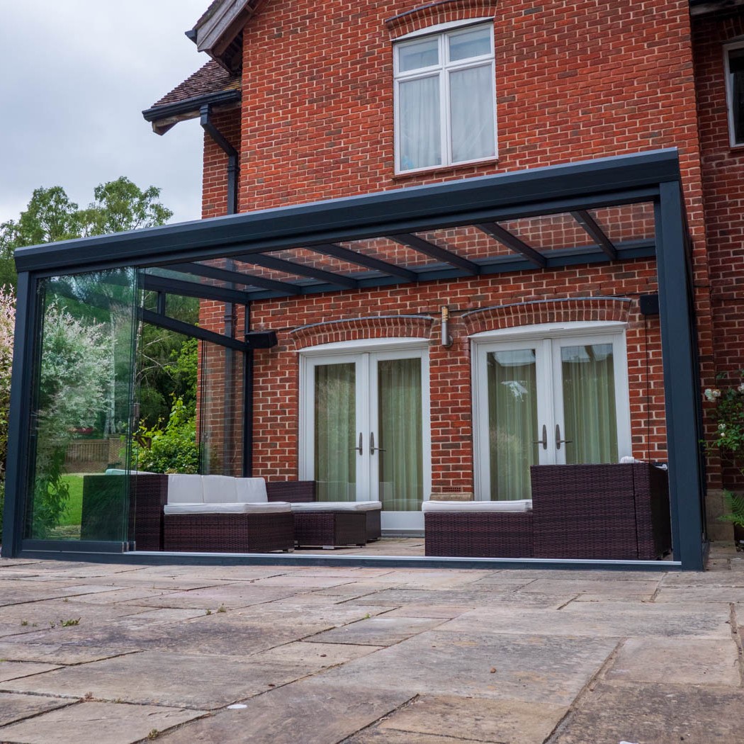 Anthracite-grey ProLine XL veranda with a glass roof over a large patio