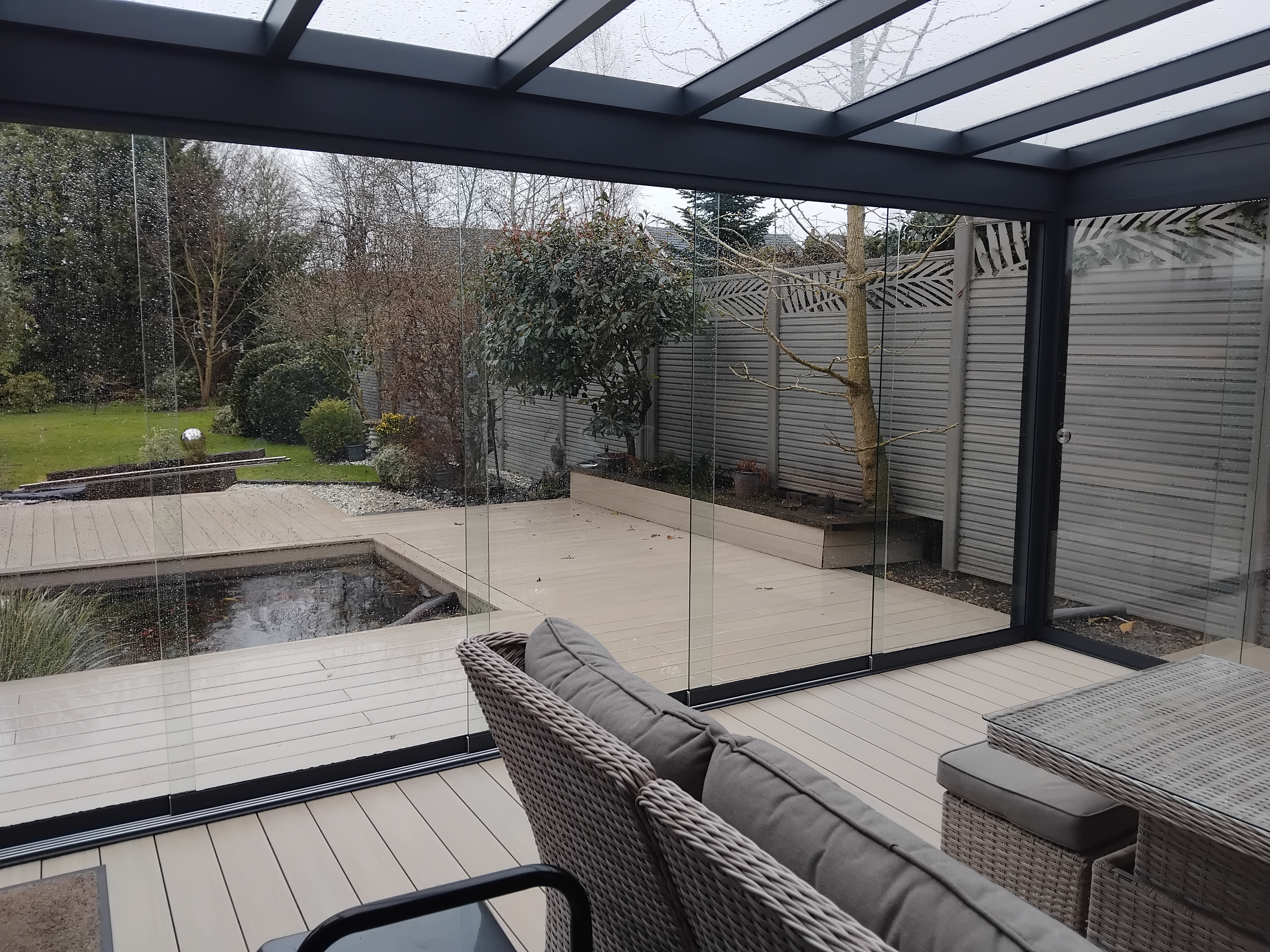 Premium fully-enclosed glass garden room beside a swimming pool