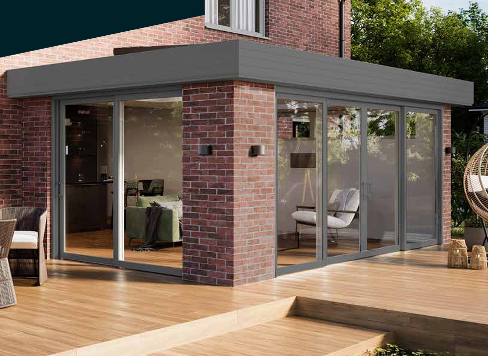 A glass garden room extension with full-height sliding glass doors, brick piers and a decked patio